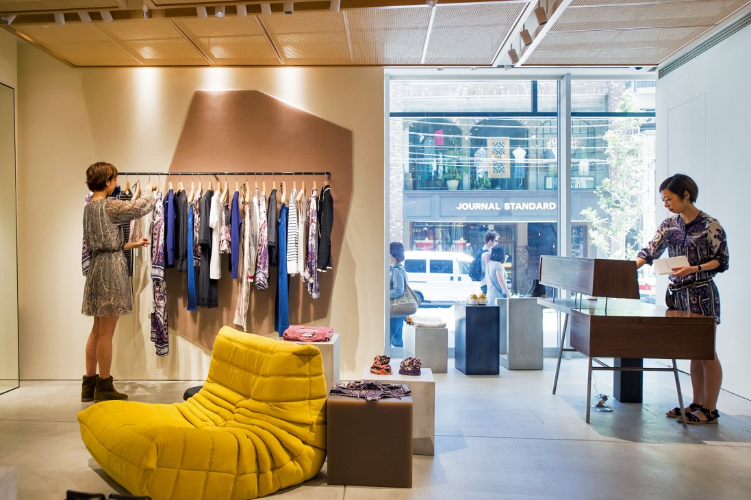 Modern retail interior with clothing display and yellow seating furniture at Newoman, Shinjuku Station Tokyo