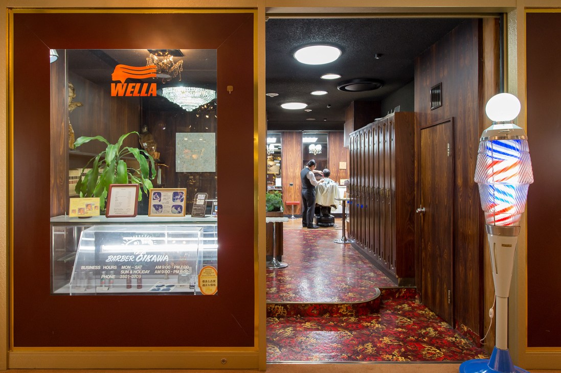 Barber Oikawa storefront and interior in Tokyo showing wood-paneled shop with signage and a barber at work.
