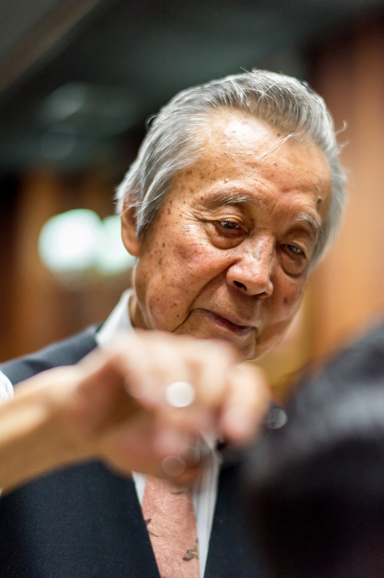 Portrait of an elderly Japanese barber in professional attire at Barber Oikawa, Tokyo.