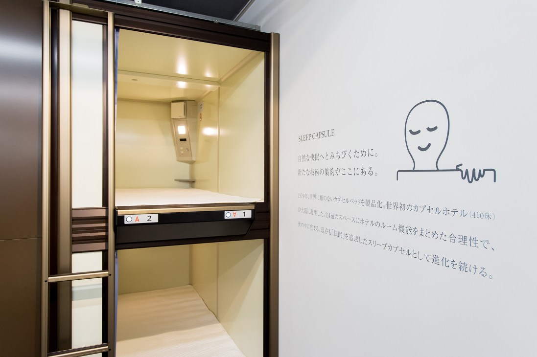 Kotobuki Seating sleeping pods with cream-colored interior and control panel for capsule hotel 9 Hours.
