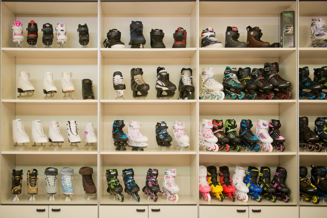 Shelving unit displaying colorful roller skates and ice skates by Roces in various sizes and designs.