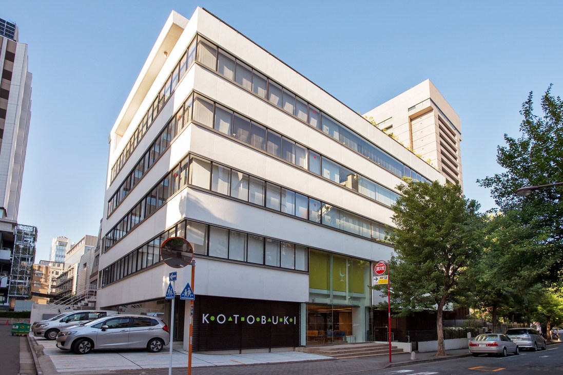 Kotobuki Seating's modernist headquarters building in Tokyo with white façade and horizontal window bands.