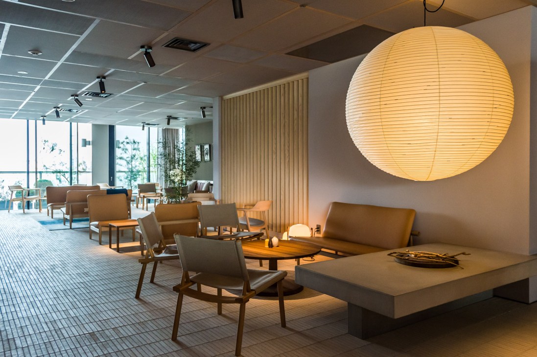 Restaurant lounge area with modern furniture including Akari paper light and Japan sofas, showcasing Nordic-Japanese design fusion