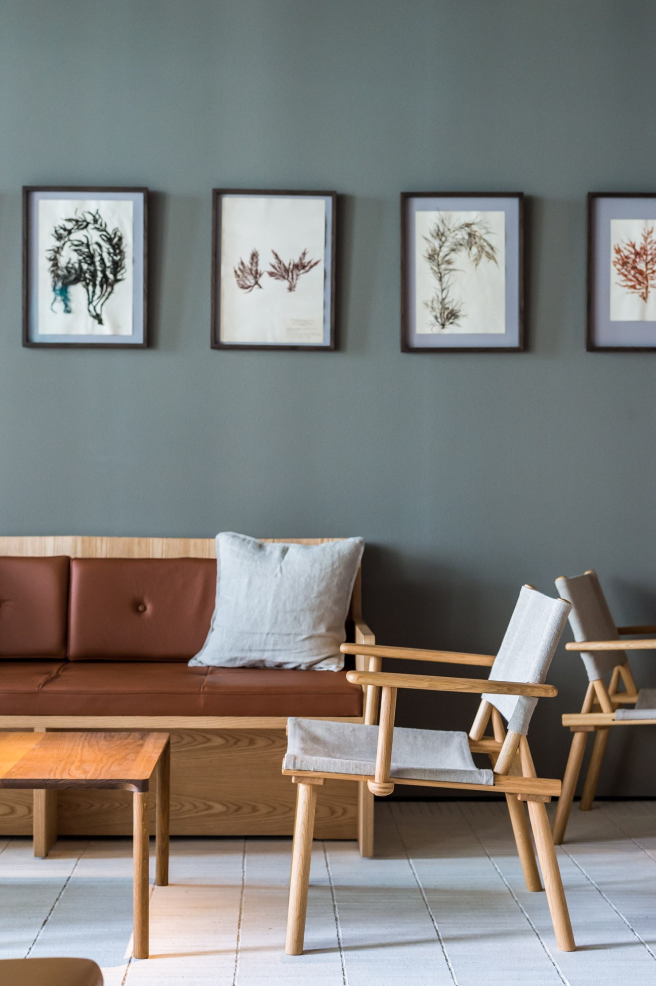 Restaurant lounge featuring custom sofa and framed seaweed artwork on walls