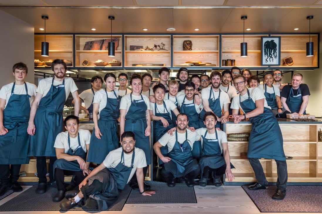 Professional kitchen team working with head chef Thomas Frebel prominently positioned among cooking staff