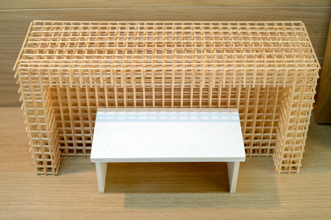 Miniature architectural model of a steel-rod-and-acrylic table with latticed wooden frame structure.