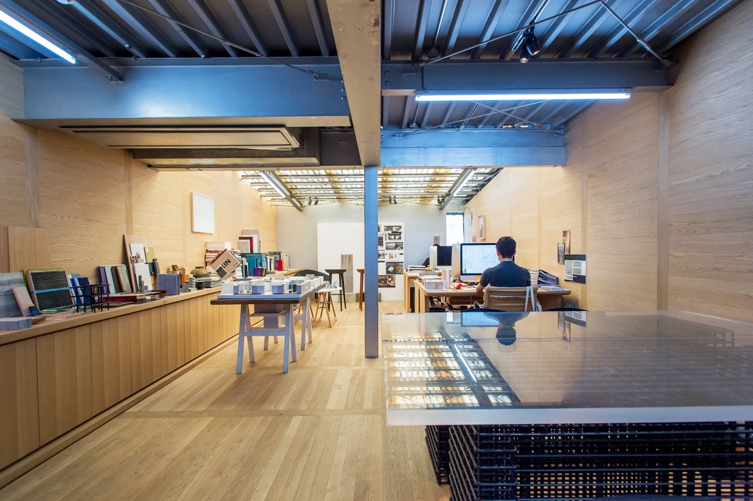 Interior of Daikei Mills offices with white oak paneling, industrial ceiling, and staff working at desks.