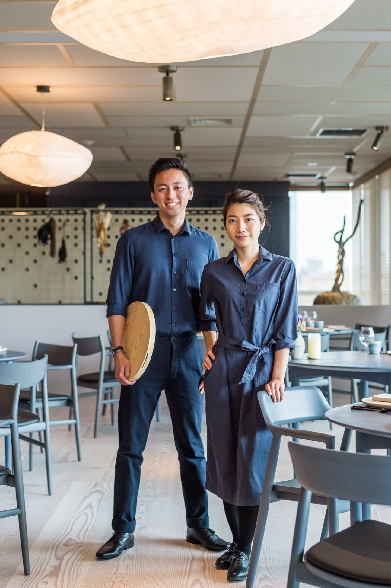 Restaurant staff members wearing matching uniforms in professional kitchen setting