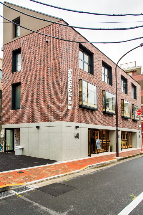 Exterior of Ridge Shoto, a three-storey brick building in Tokyo with modern design elements and ground-floor storefront.