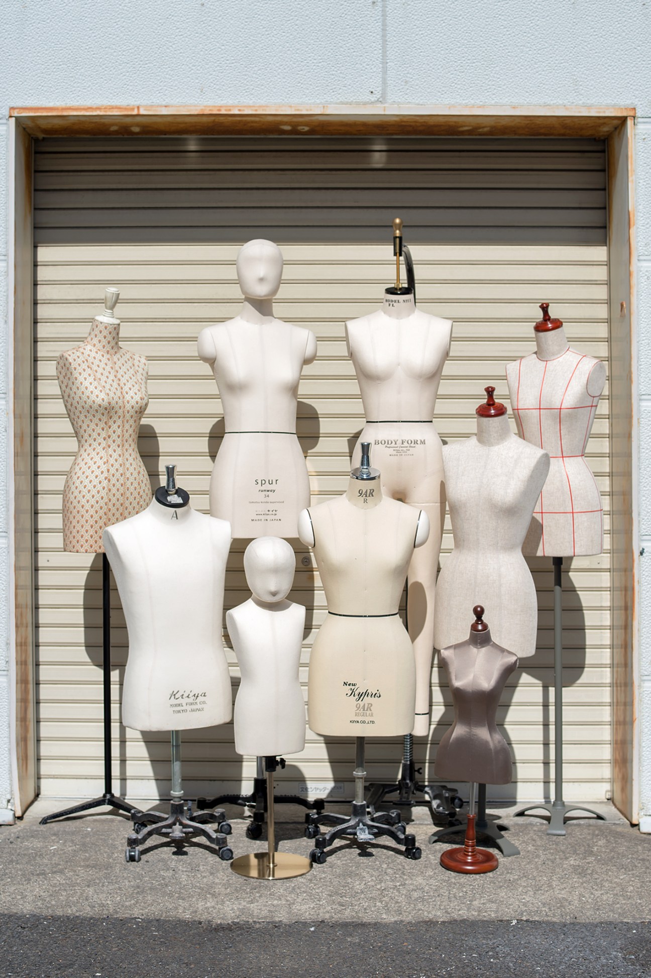 Display of Kiiya mannequins in various sizes and body types against a slatted backdrop.