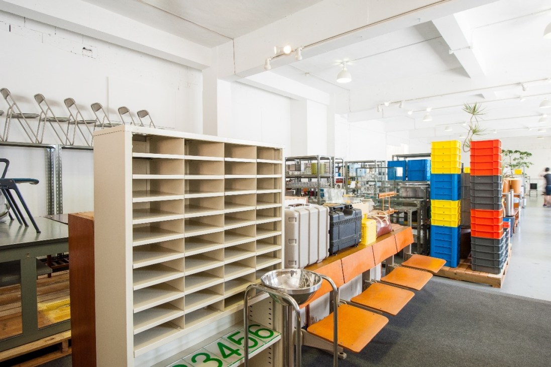 Interior of D&Department store in Okinawa showing modular shelving, colorful storage boxes, and design products.