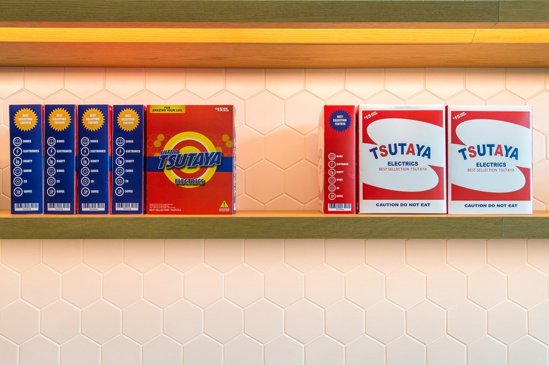 Shelf display of decorative boxes designed to resemble detergent packaging at Tsutaya Electrics.