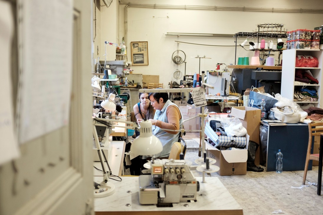 A student and teacher work together at sewing machines in a design studio at Mome university.