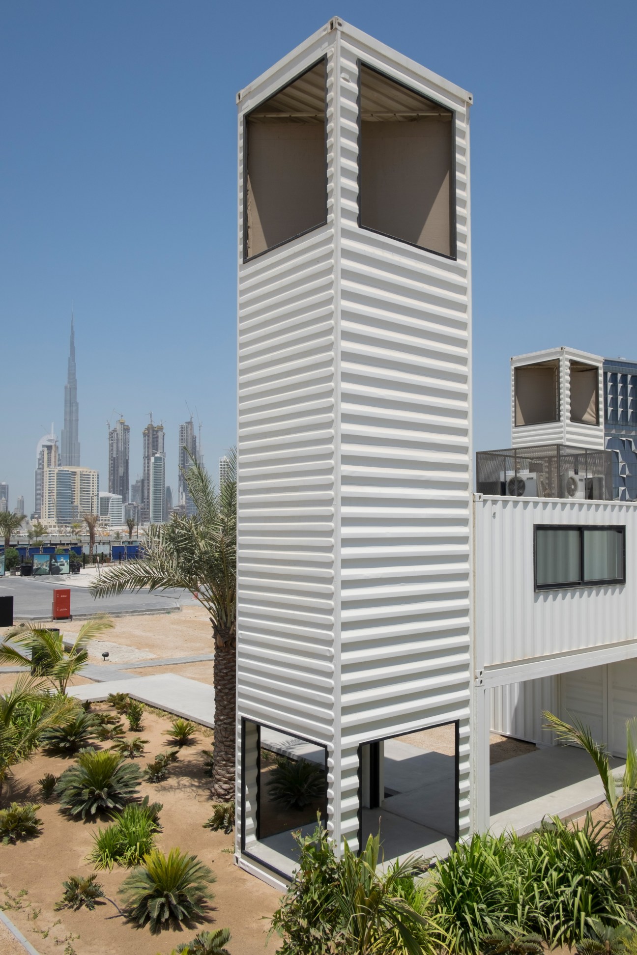 Tall white ribbed tower structure housing Hai D3, the Design and Fashion Council, with Dubai skyline and Burj Khalifa visible in background.