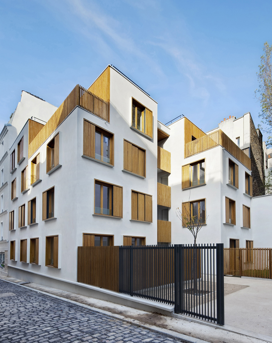 Modern white apartment building with wooden window shutters and balconies in Paris by Explorations Architecture.