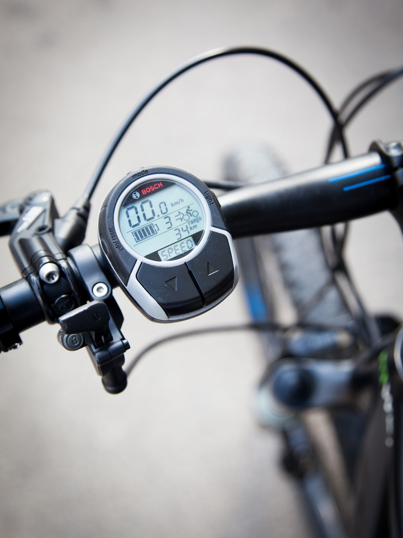 Close-up of a Bosch digital display on an e-bike handlebar showing speed, battery charge and range.