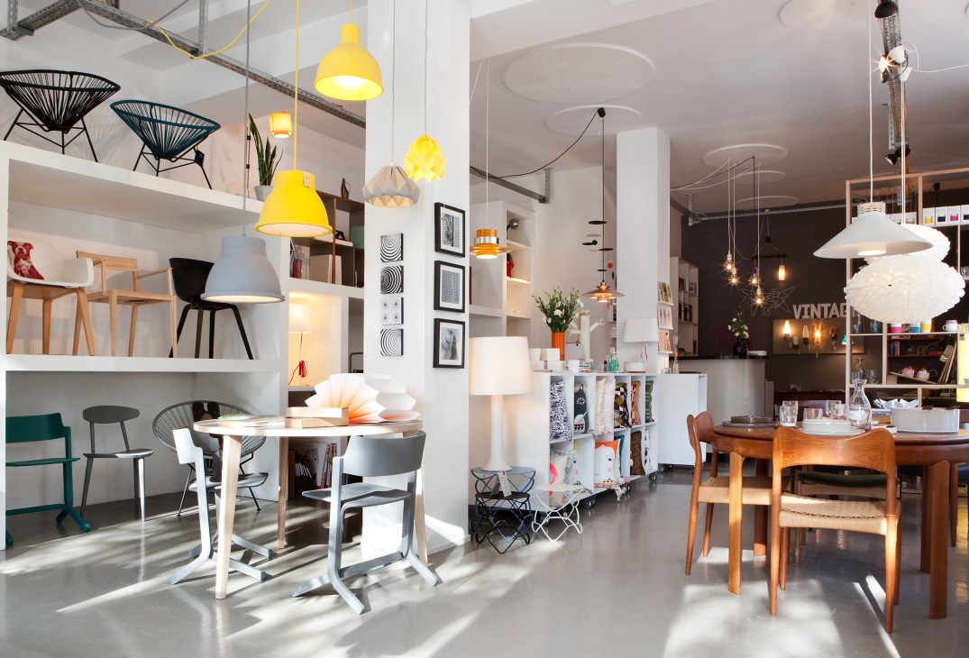 Interior of TØNDEL design shop with pendant lamps, furniture displays, and curated home decor items.