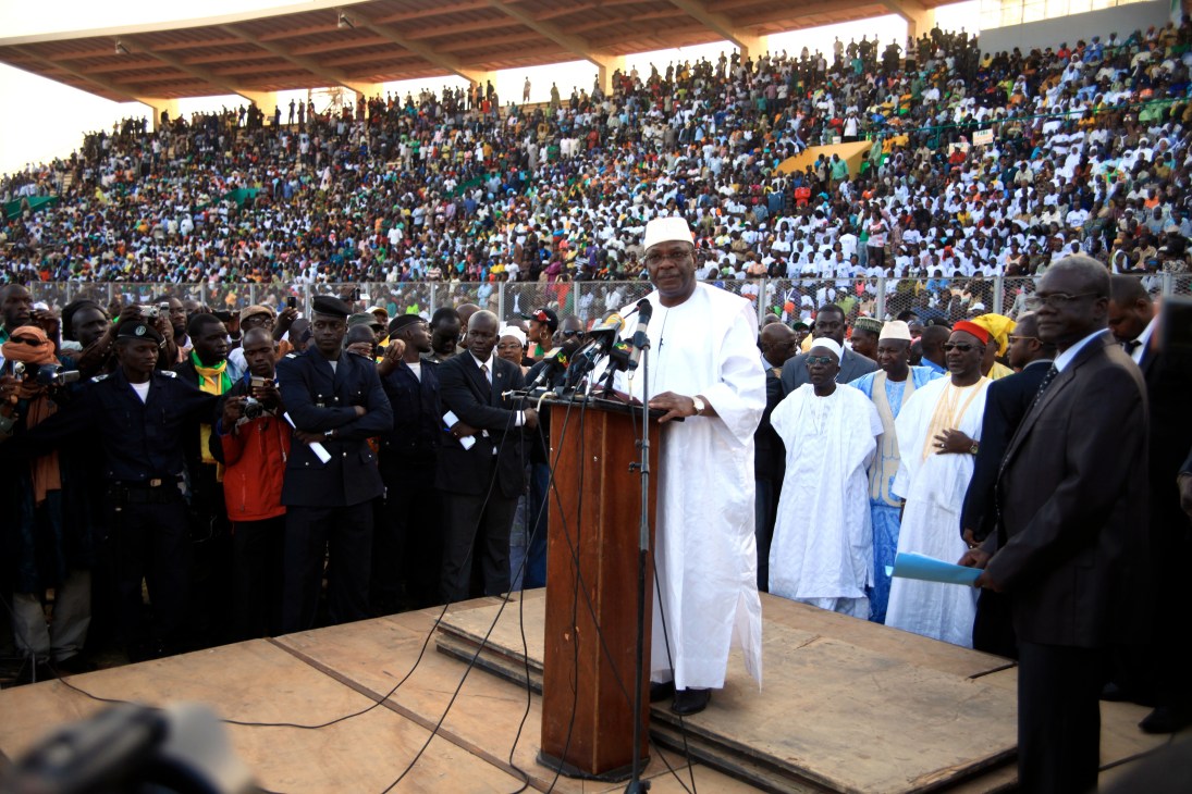 Mali presidential candidate Ibrahim Boubacar Keïta speaking at a podium during a campaign rally in a crowded stadium.