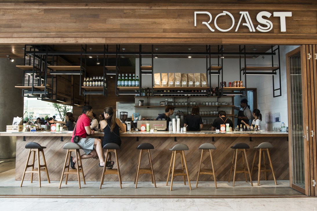 Roast coffee shop storefront at EmQuartier with wooden counter and bar seating