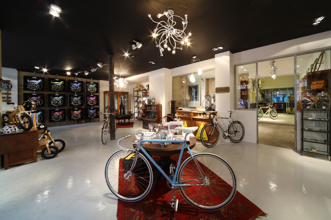 Modern luxury bicycle shop interior with vintage bikes on display and wall-mounted neon bike art.