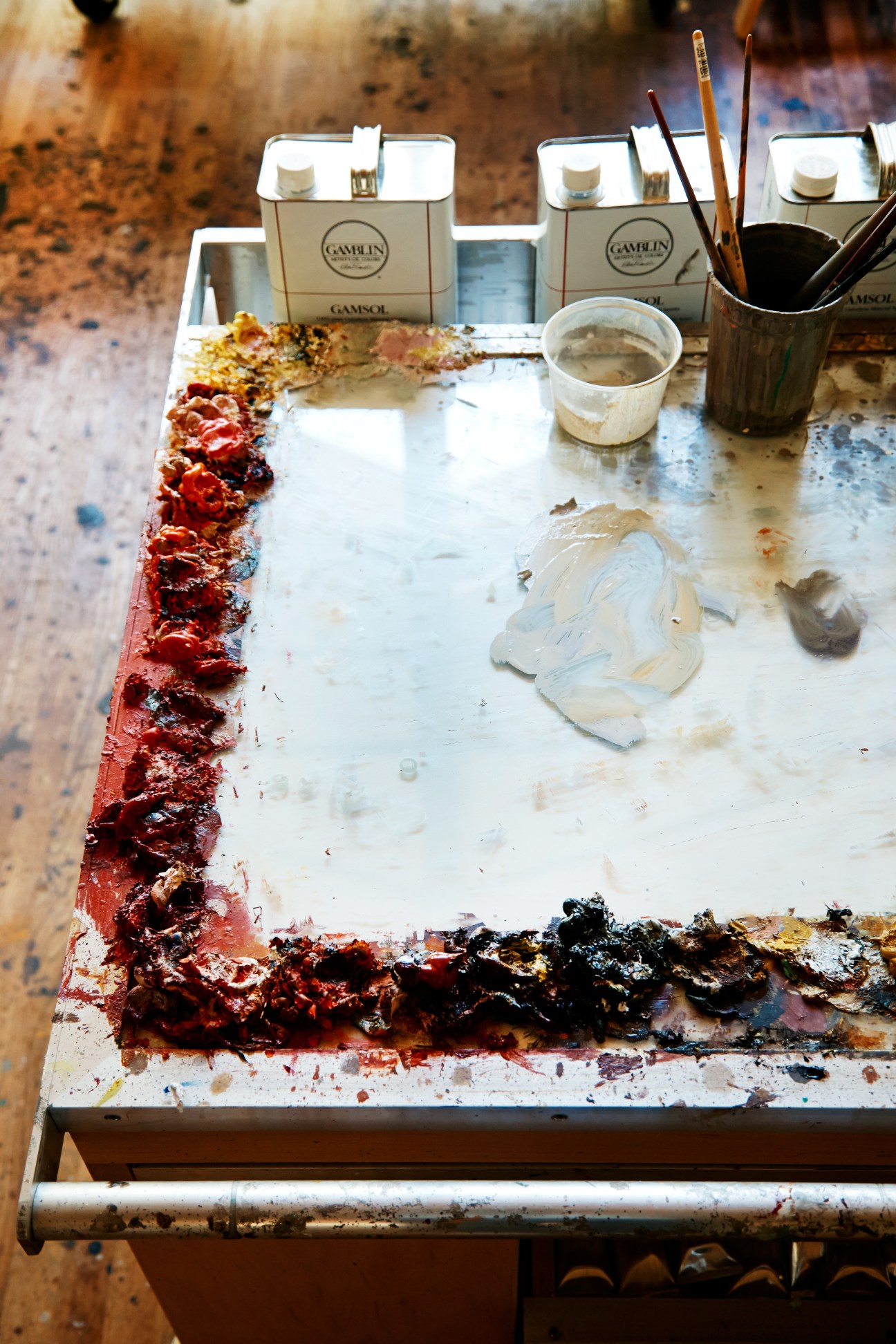 Artist's palette with Gamblin oil paints, brushes, and paint-covered surface in Eric Fischl's studio.