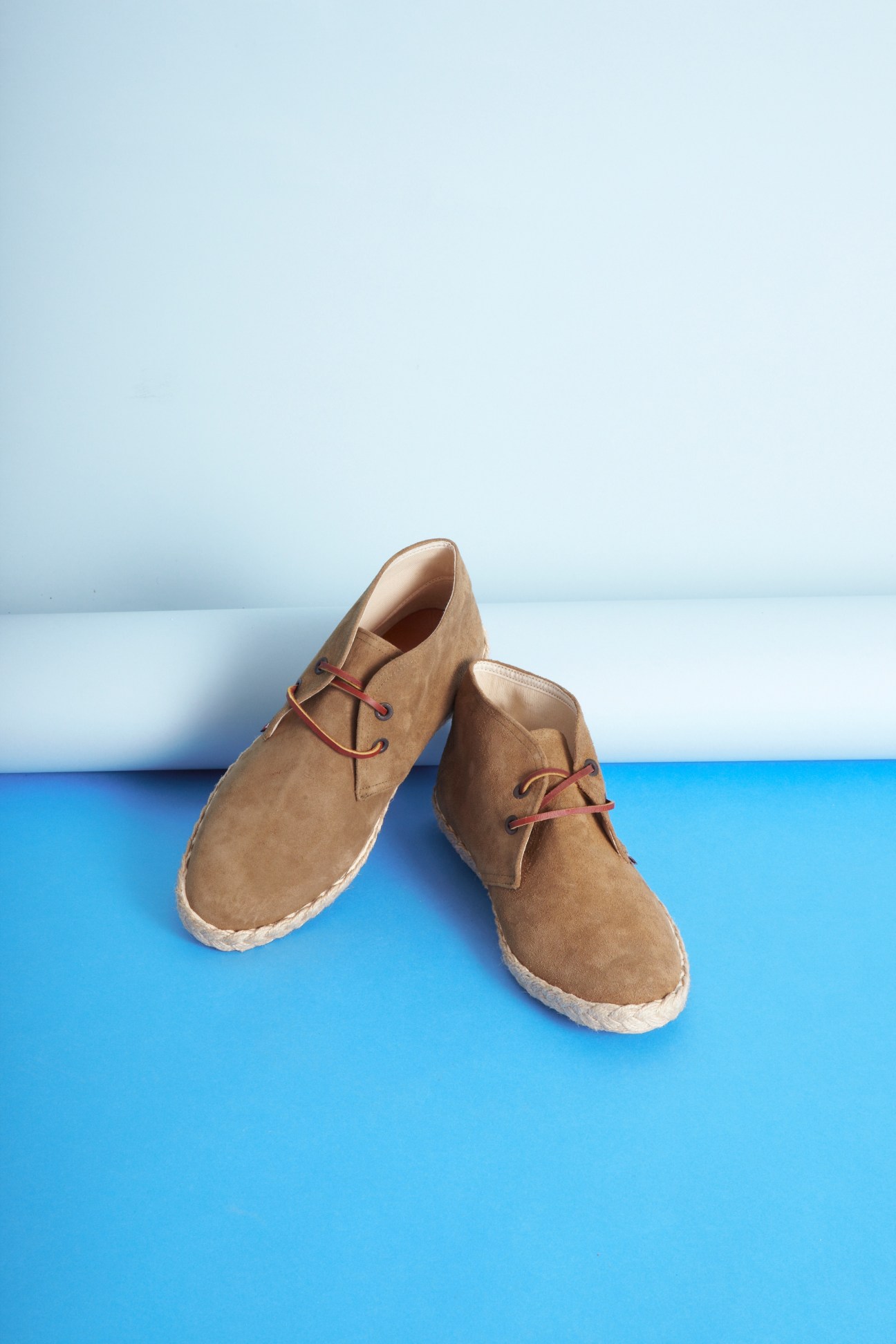 Pair of tan suede chukka boots with red laces and rubber sole by Veras Shoes.