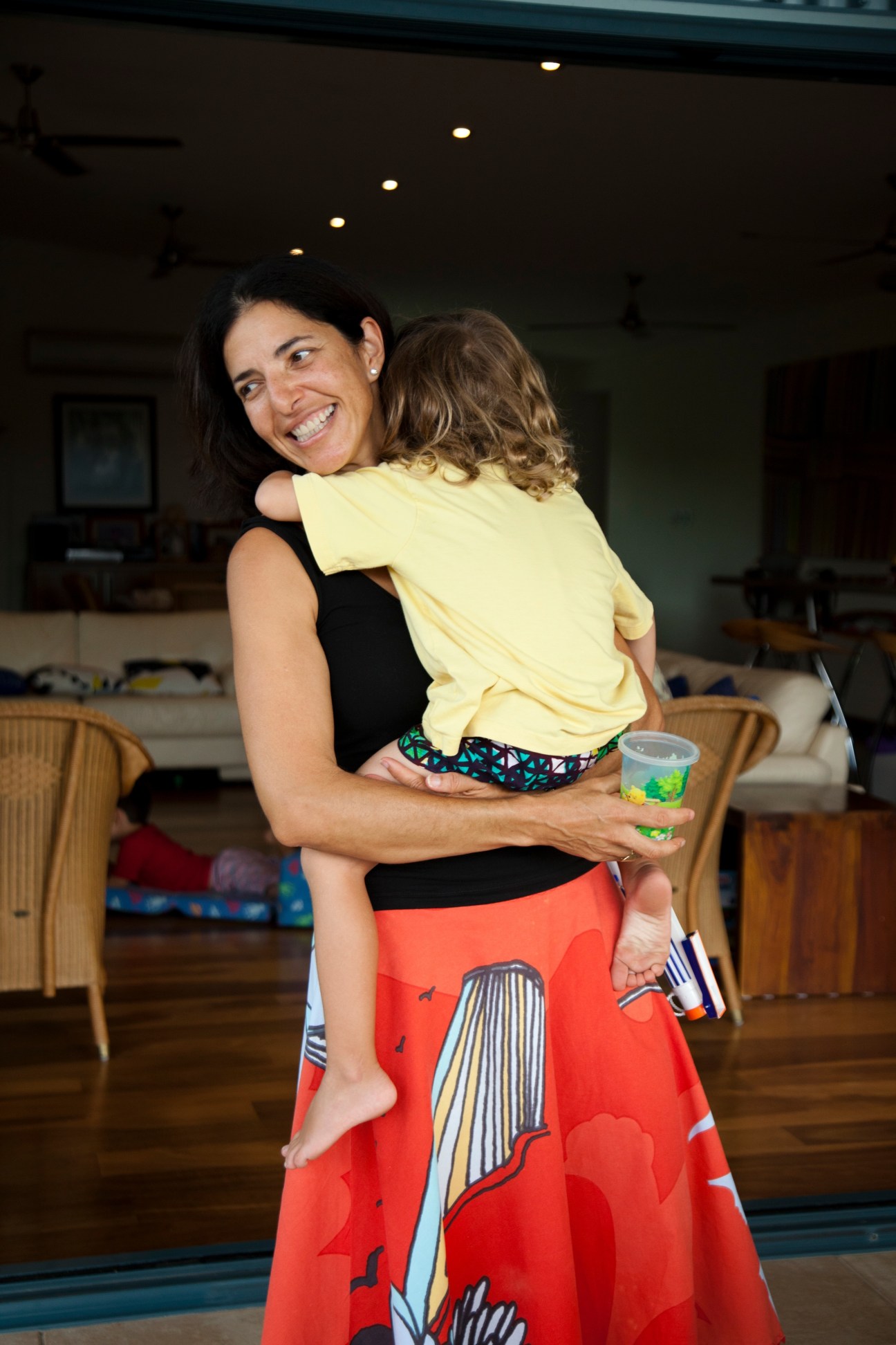 Woman holding a young child in a bright modern home interior
