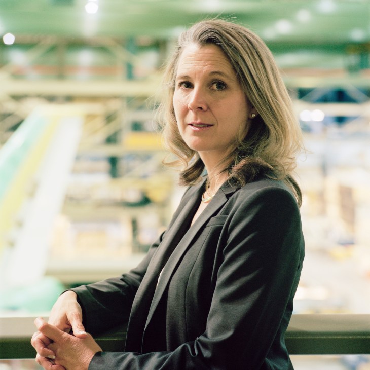 Elizabeth Lund, president of the Boeing 747 programme, posing at the Everett factory with aircraft assembly visible behind her.