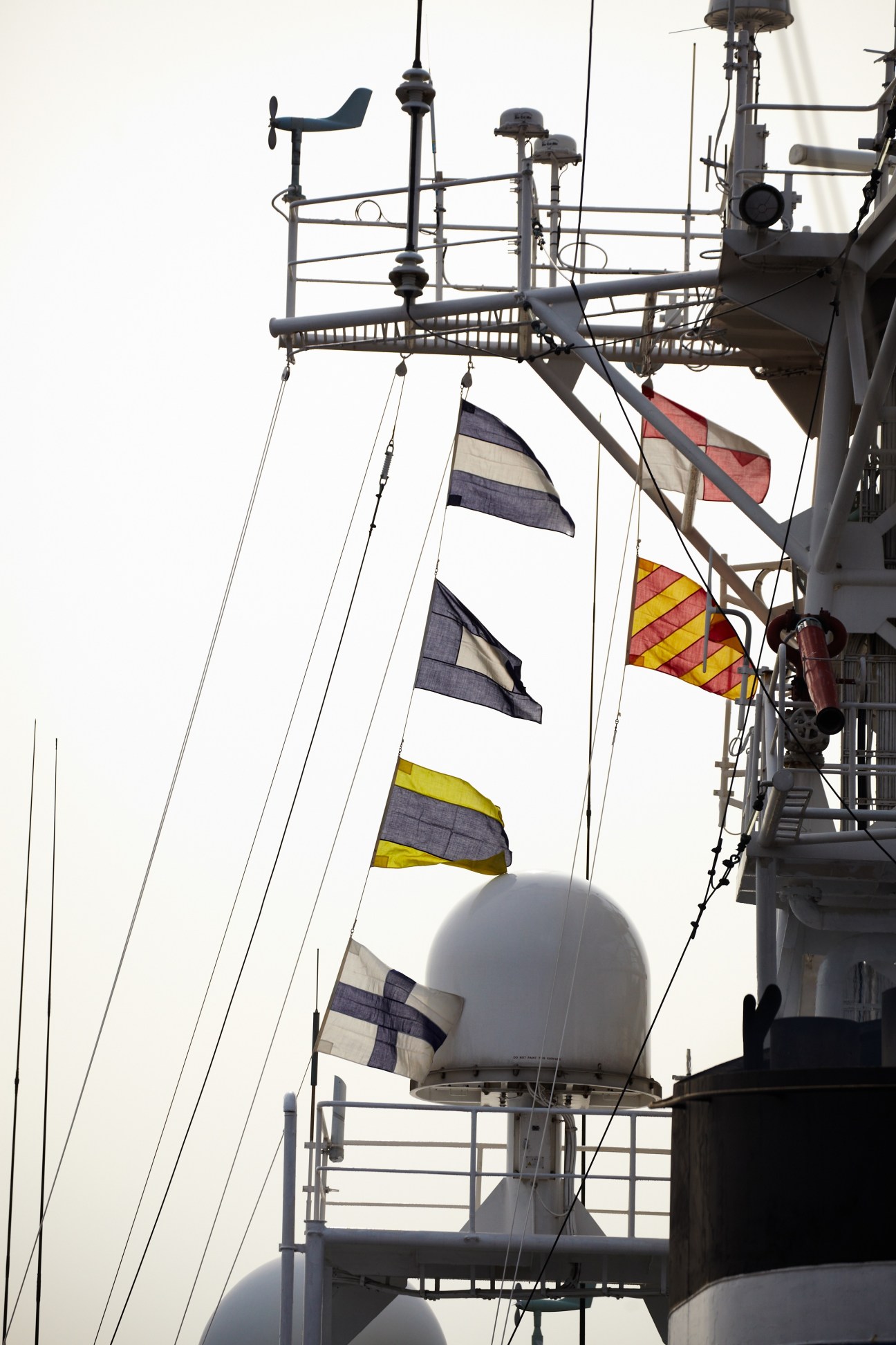 Detail of JCG patrol vessel Yashima showing flags, antenna, and radar dome against sky