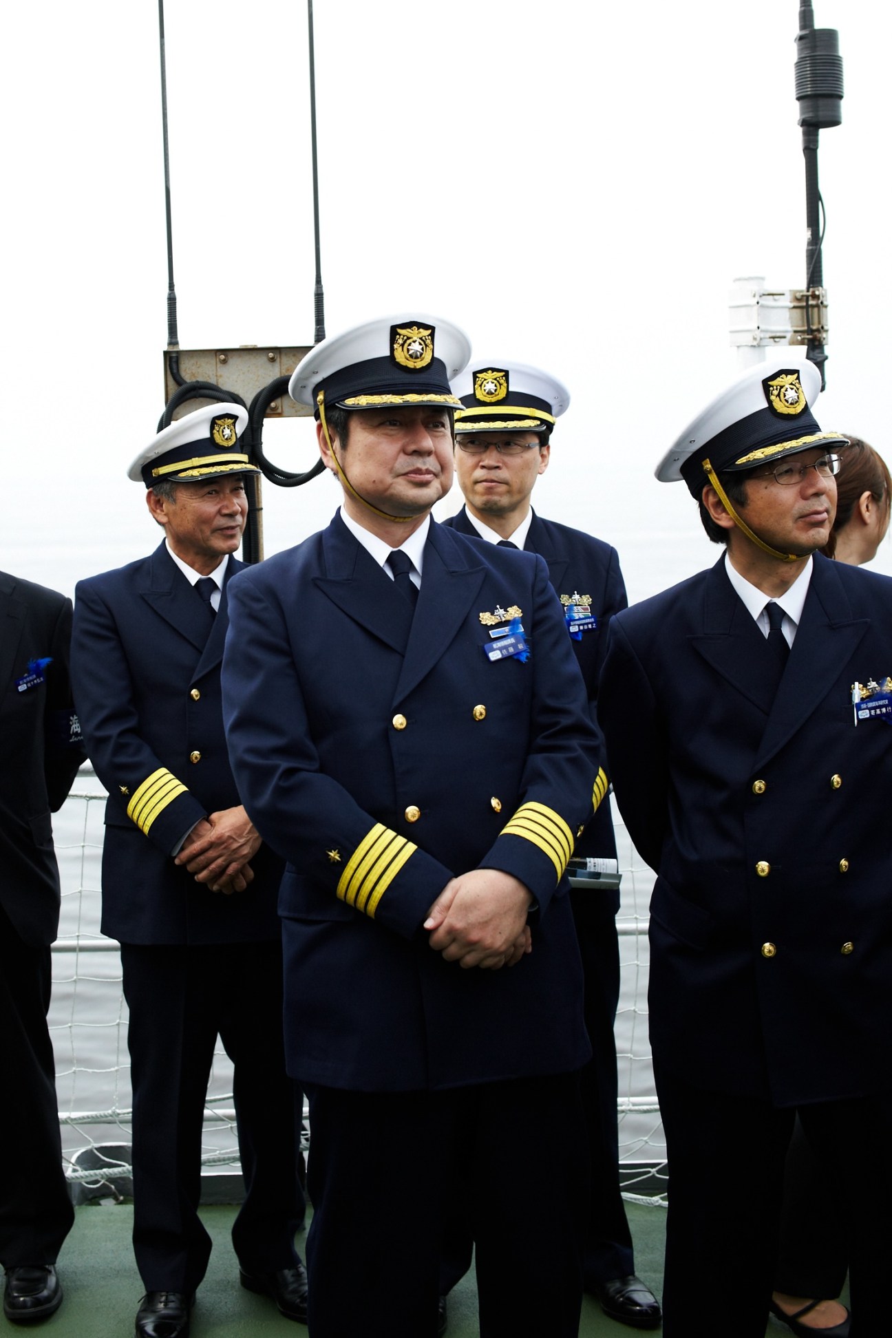 Japan Coast Guard officers in dress uniforms standing on the deck of patrol vessel Yashima.