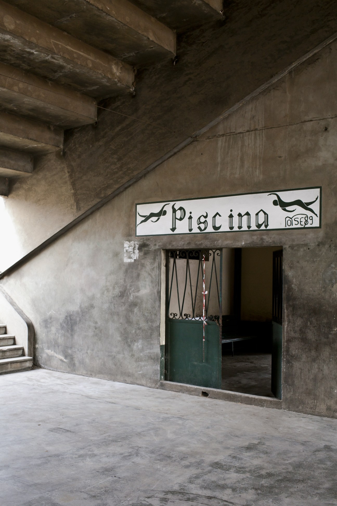 Pool entrance at Ferroviário de Maputo sports club showing concrete brutalist architecture with hand-painted signage.