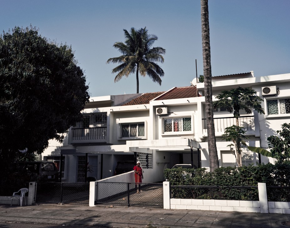 White Art Deco residential building with palm tree and tropical vegetation in Maputo.