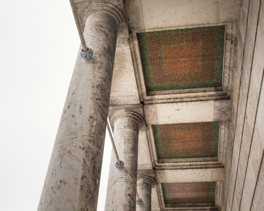 Concrete columns and ceiling detail showing Nazi-era mosaic patterns with swastikas at Haus der Kunst Munich.