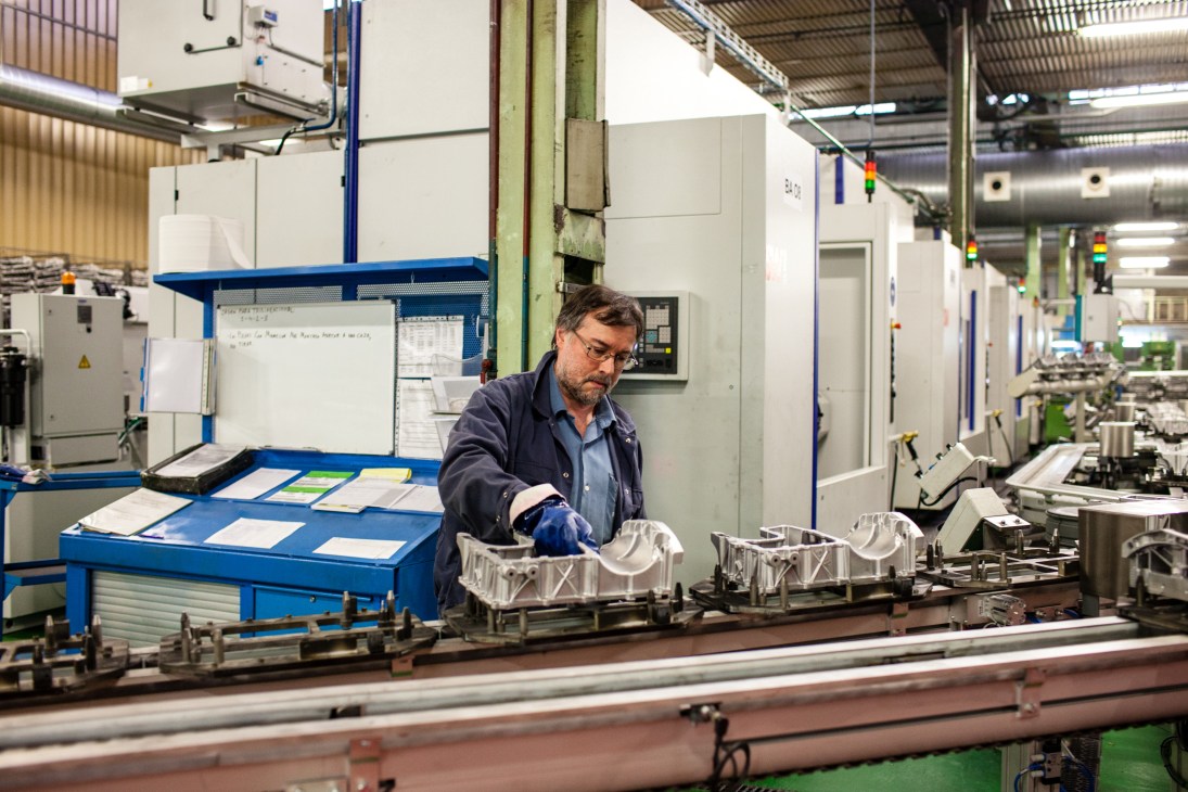 A worker assembles metal components on a production line at Fagor Ederlan factory.