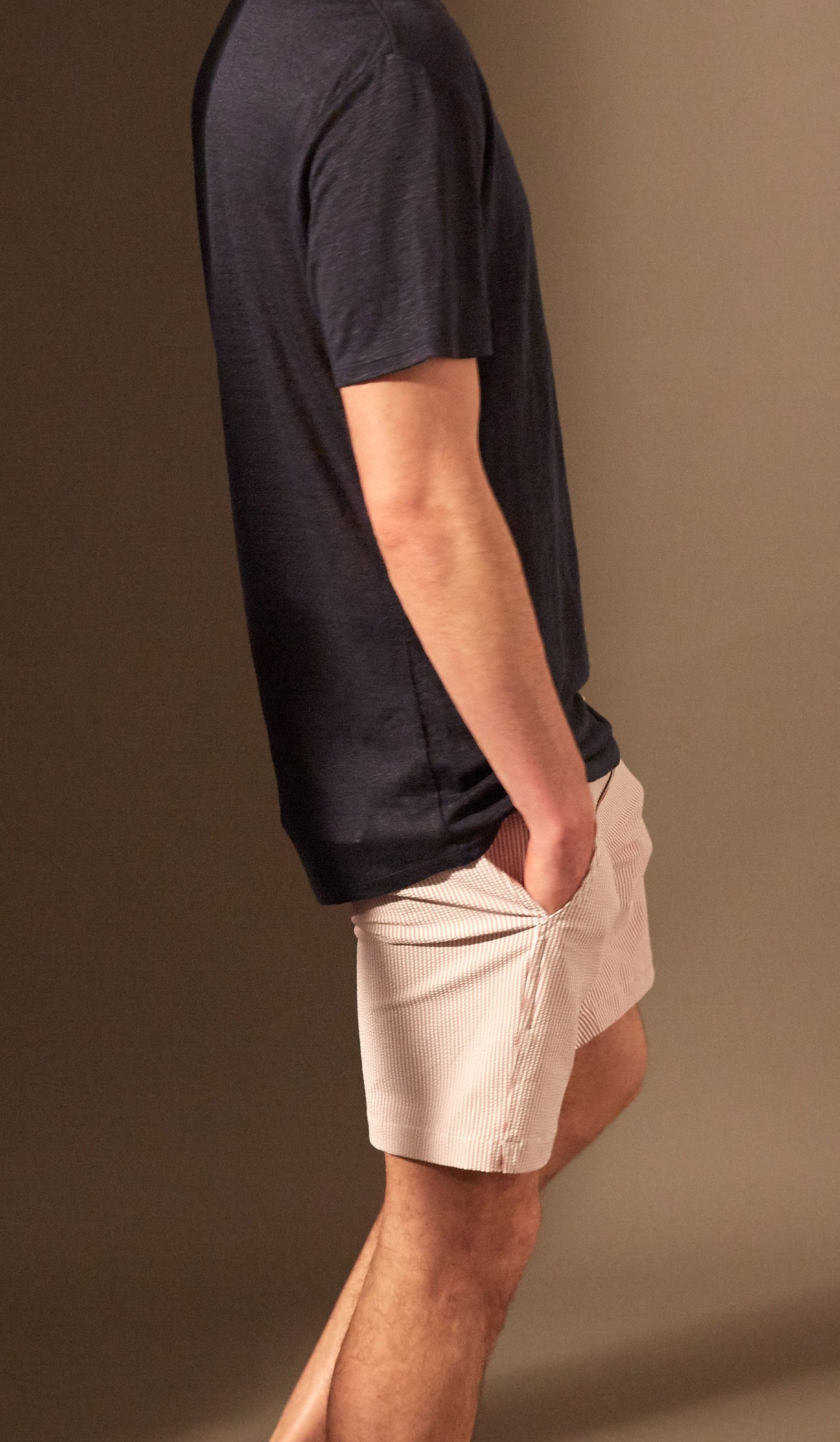 Man wearing a dark navy t-shirt and light cream ribbed swim shorts by Onia.