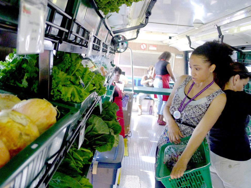 Customer shopping for fresh produce inside Fresh Moves mobile grocery bus in Chicago.