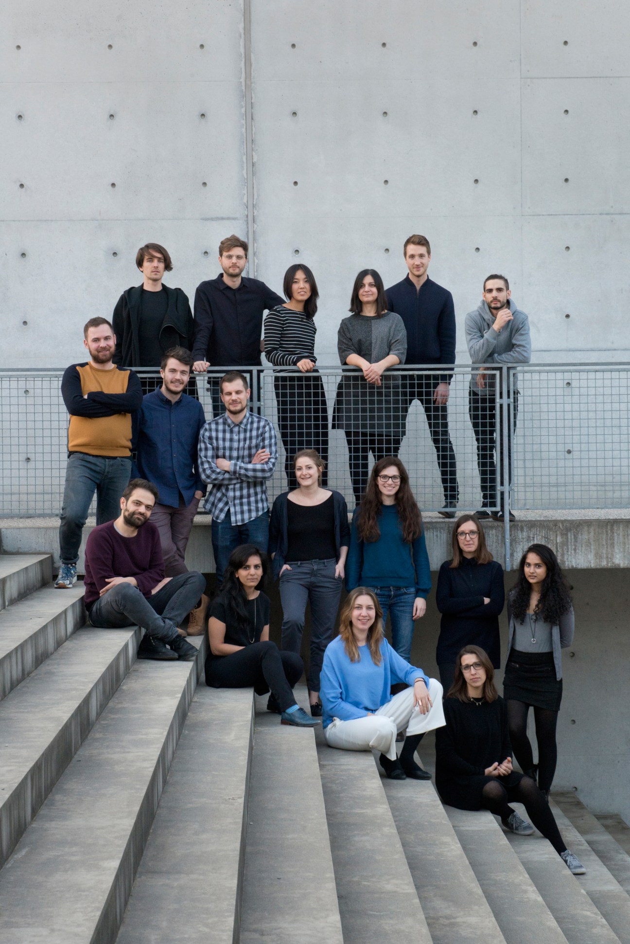 Fabrica team of designers posing on steps in front of a concrete building.