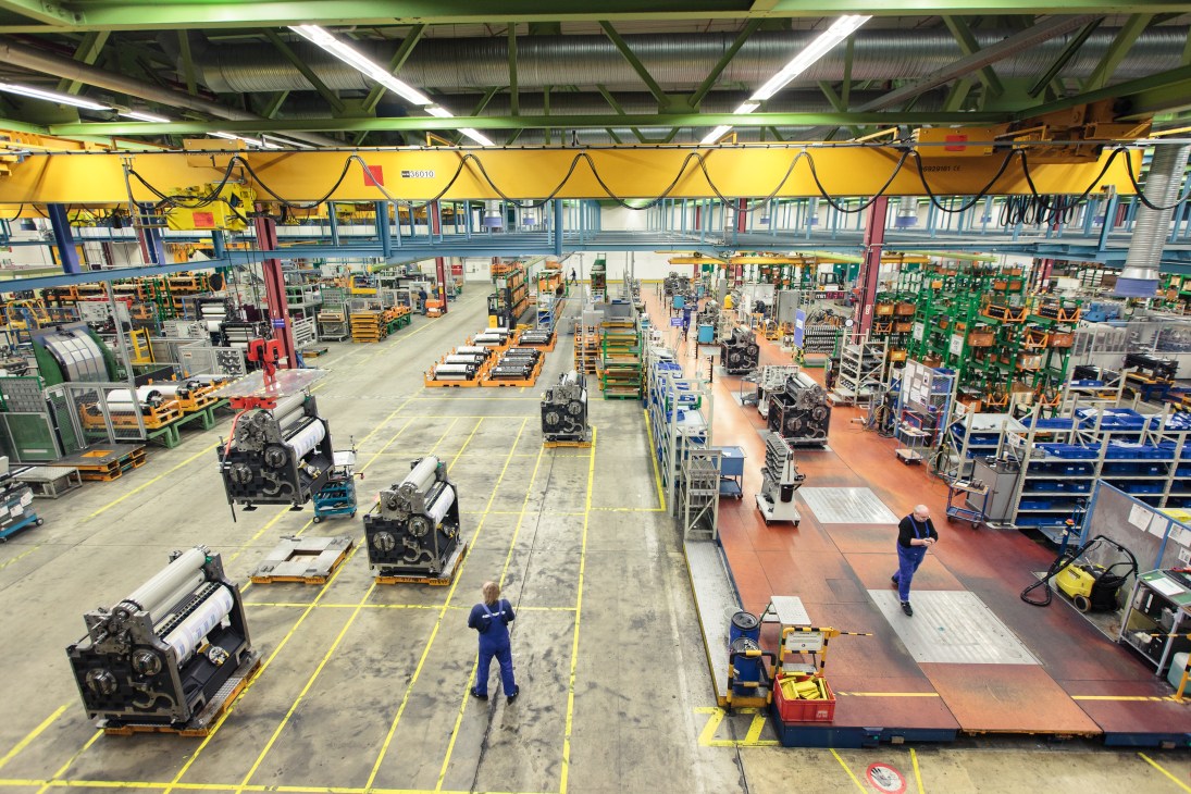 Interior of Heidelberg Druckmaschinen manufacturing facility showing large industrial machinery and printing press components on the factory floor.