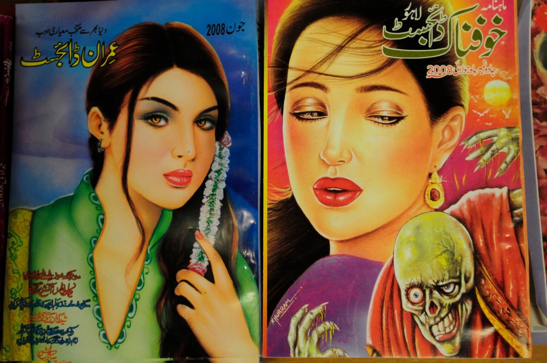 Colourful Pakistani fiction paperback covers with Urdu text displayed on bookshop shelves.