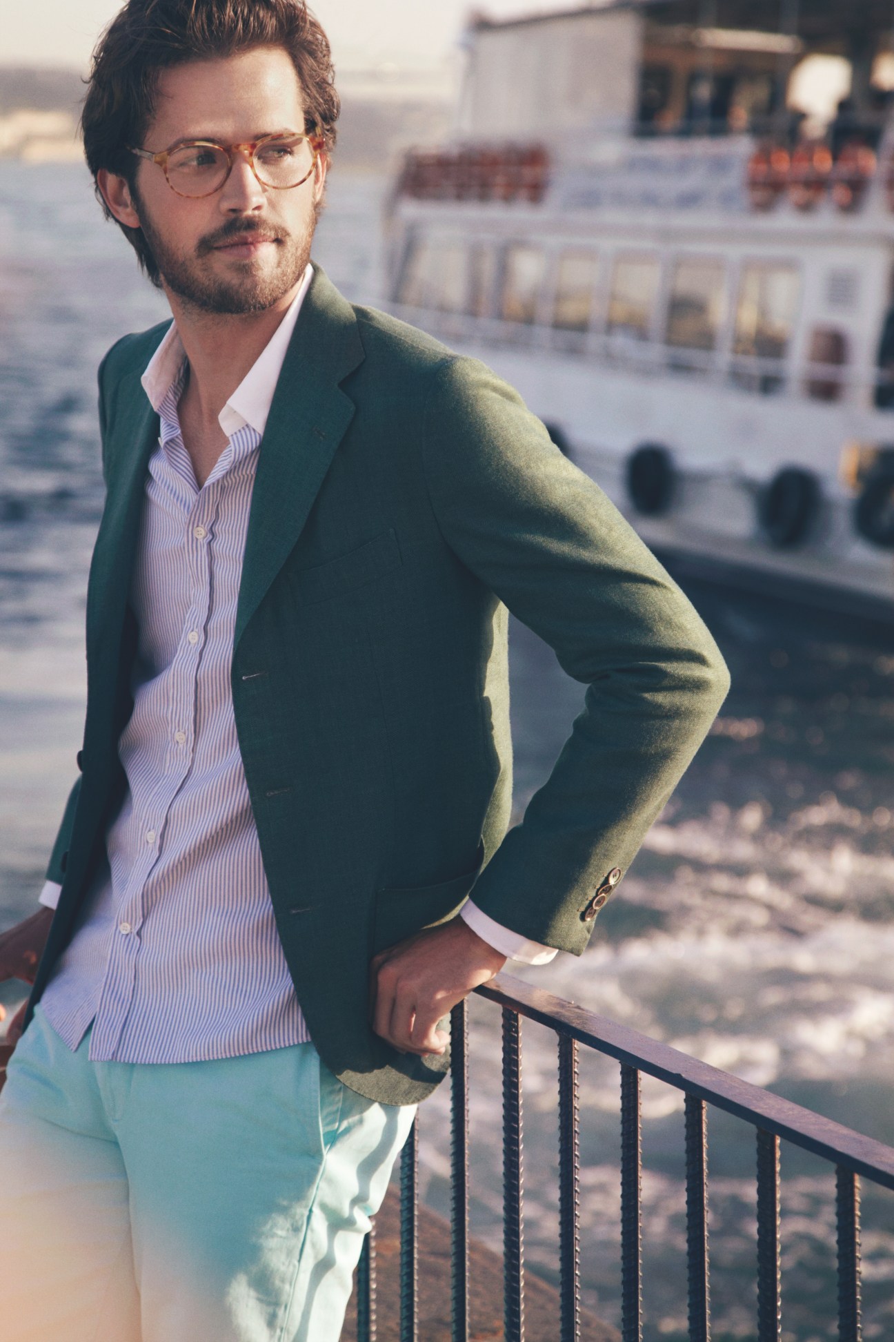 Man wearing Michel Henau glasses, Sartorio jacket, and Maison Kitsuné shirt on a Bosphorus ferry.