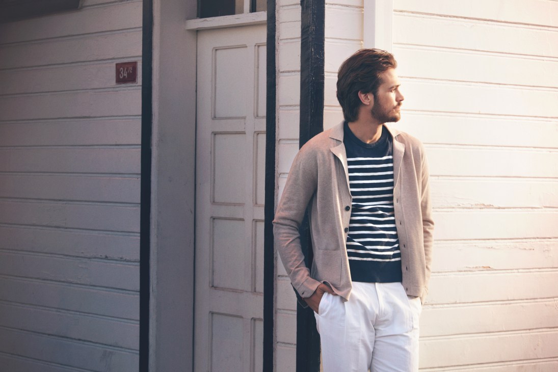 Male model wearing Roda jacket, J.Crew t-shirt, and Louis Vuitton trousers against white wooden doors.
