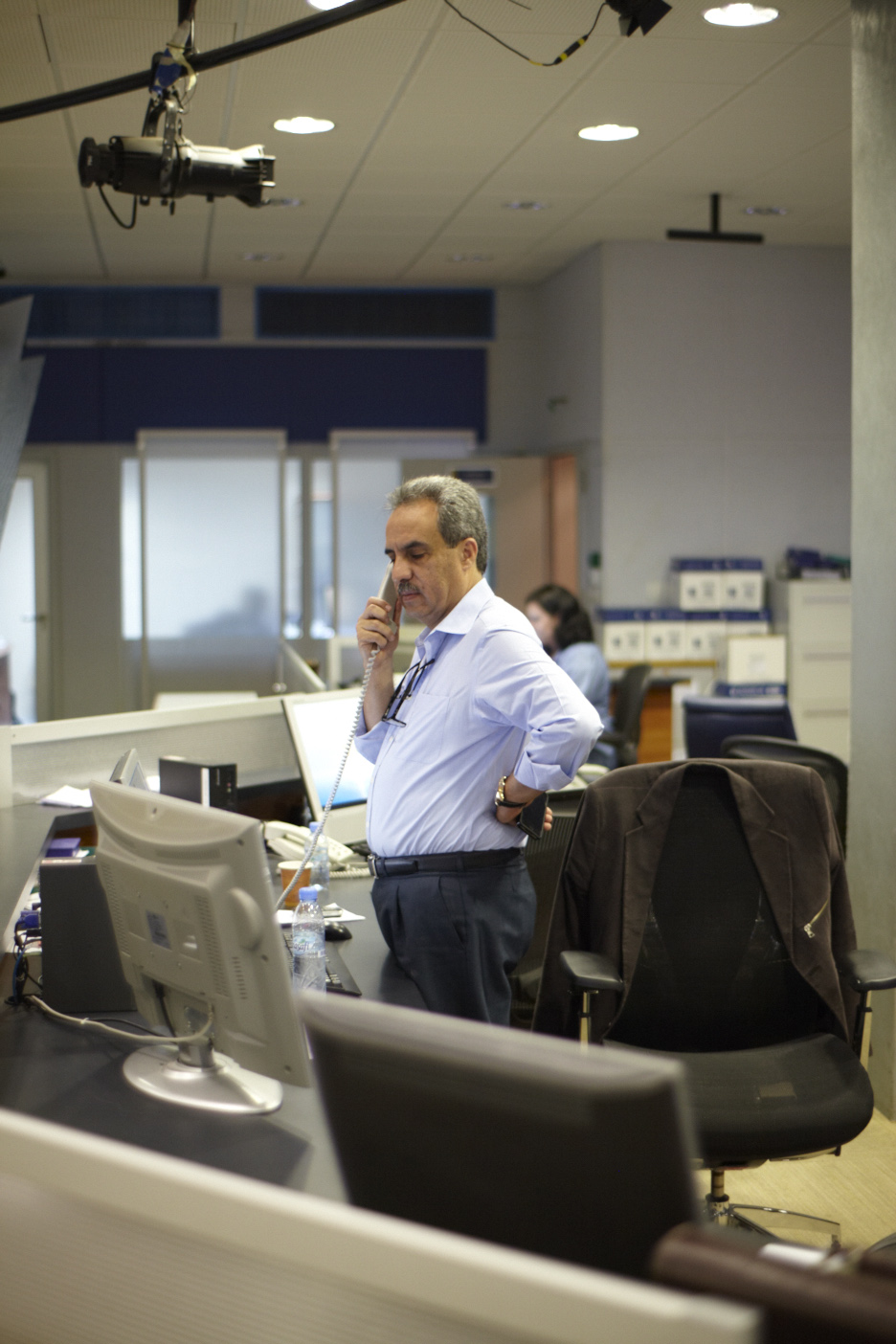 News anchor Mohamed Krichen speaks on phone in Al Jazeera Arabic newsroom studio.