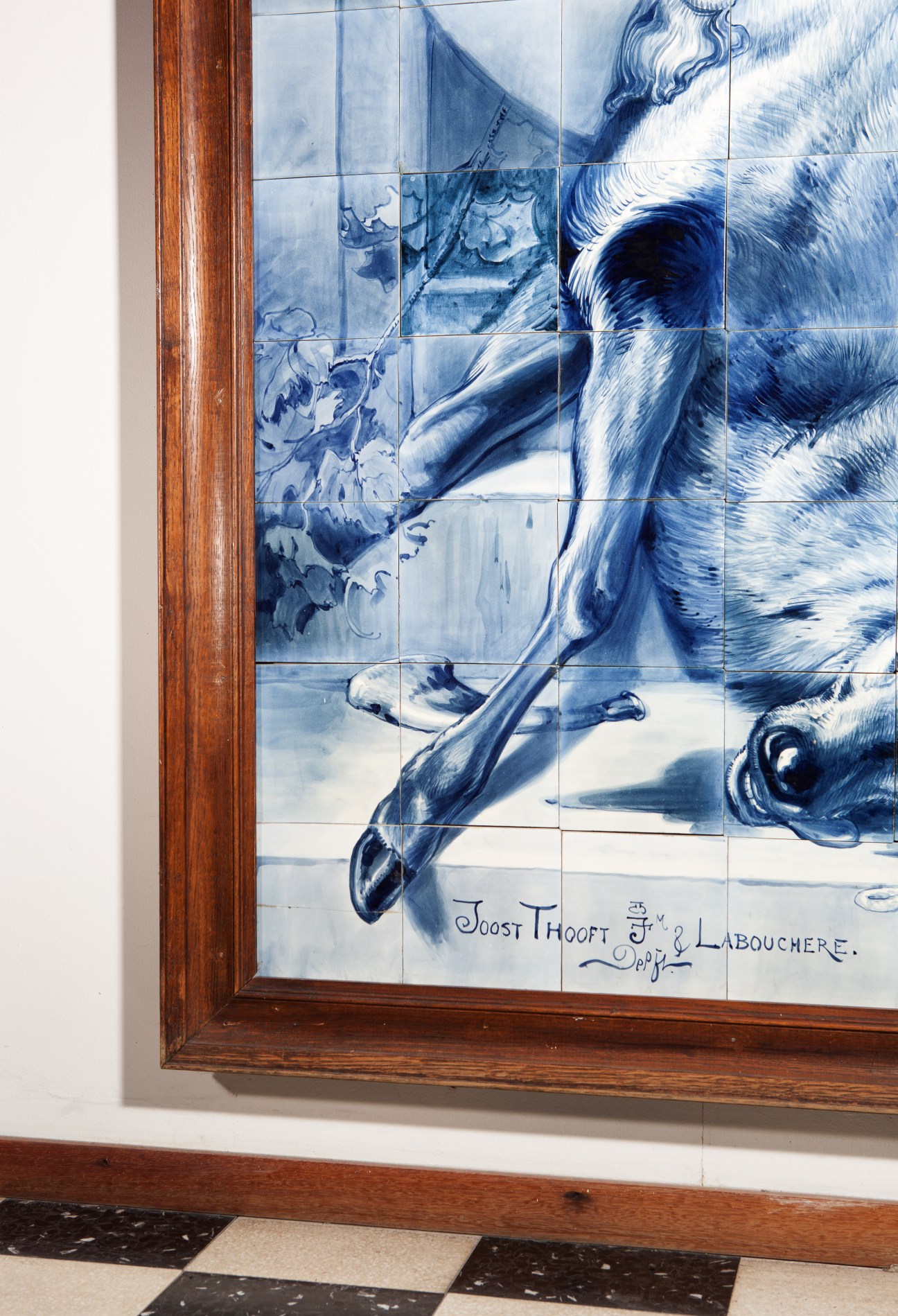 Blue and white ceramic tile painting depicting a figure in detailed brushwork, displayed at Royal Delft