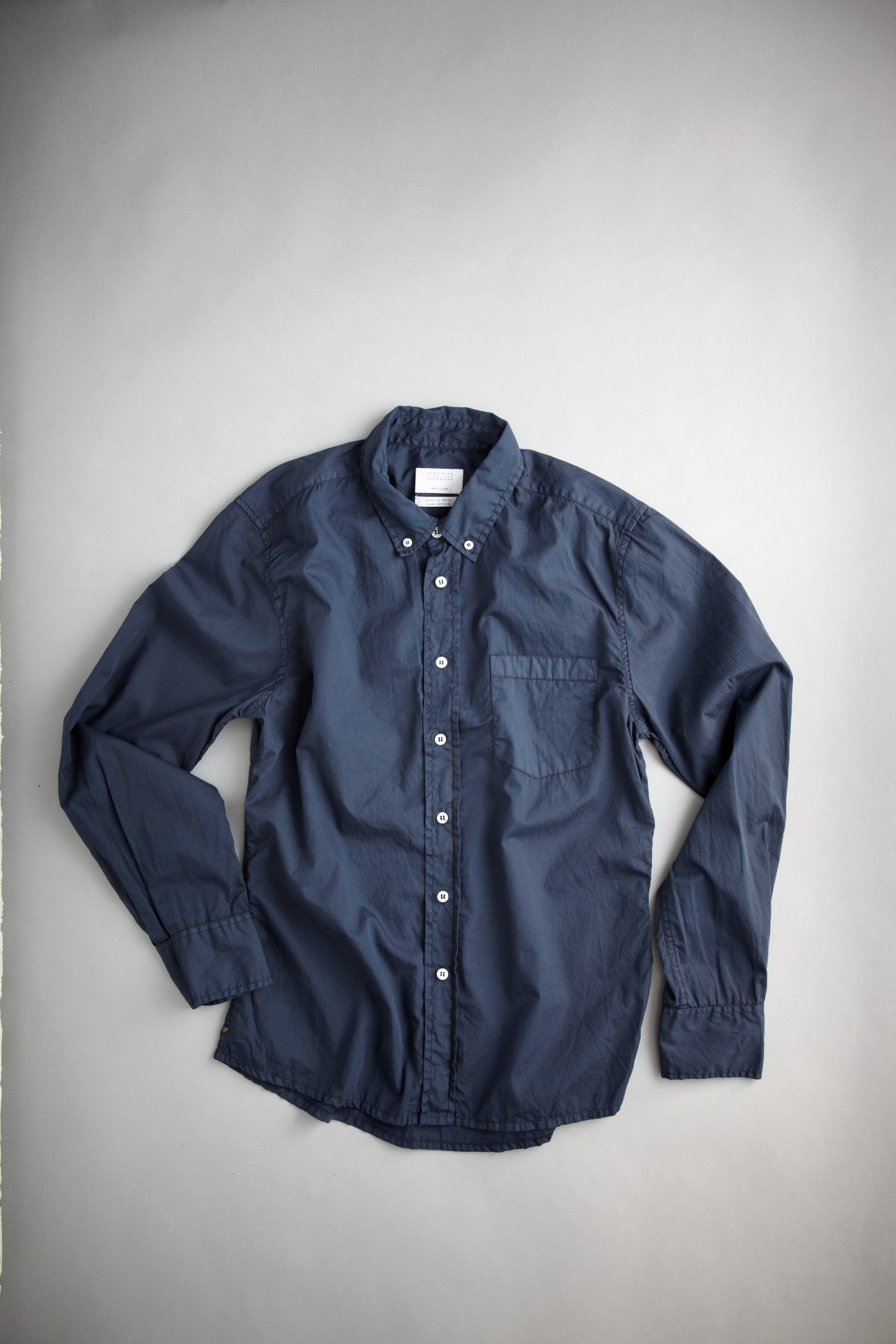 Navy blue long-sleeve button-up shirt with chest pocket on white background.