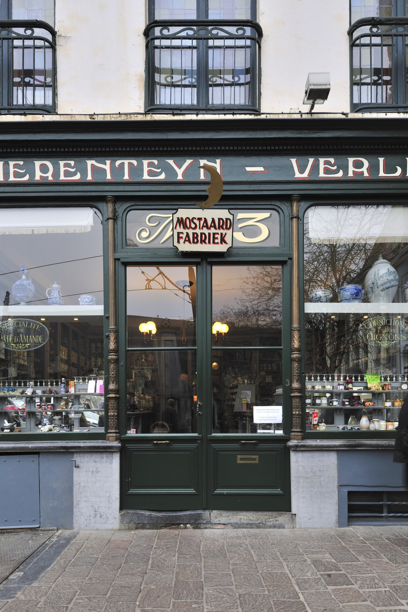 Tierenteyn-Verlent mustard shop storefront with green doors and ornate signage in Ghent.