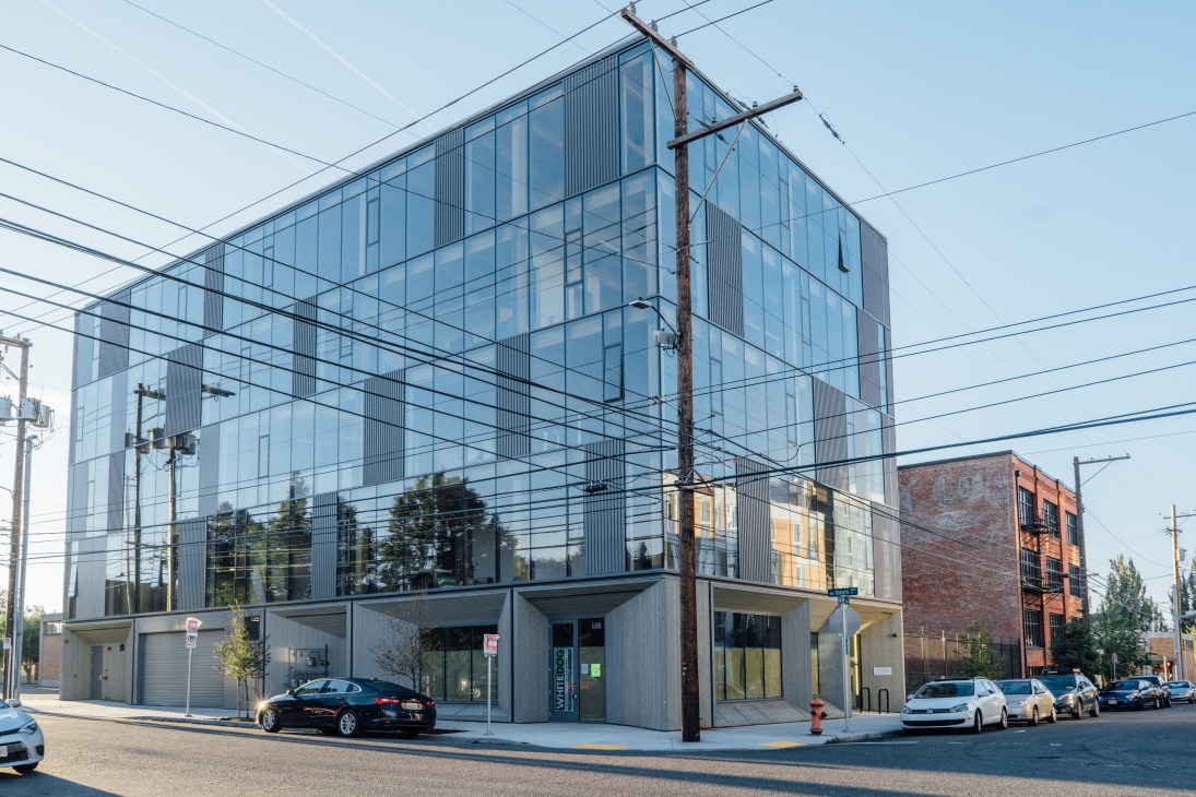Modern glass and concrete Framework building with extensive curtain wall windows and power lines crossing overhead
