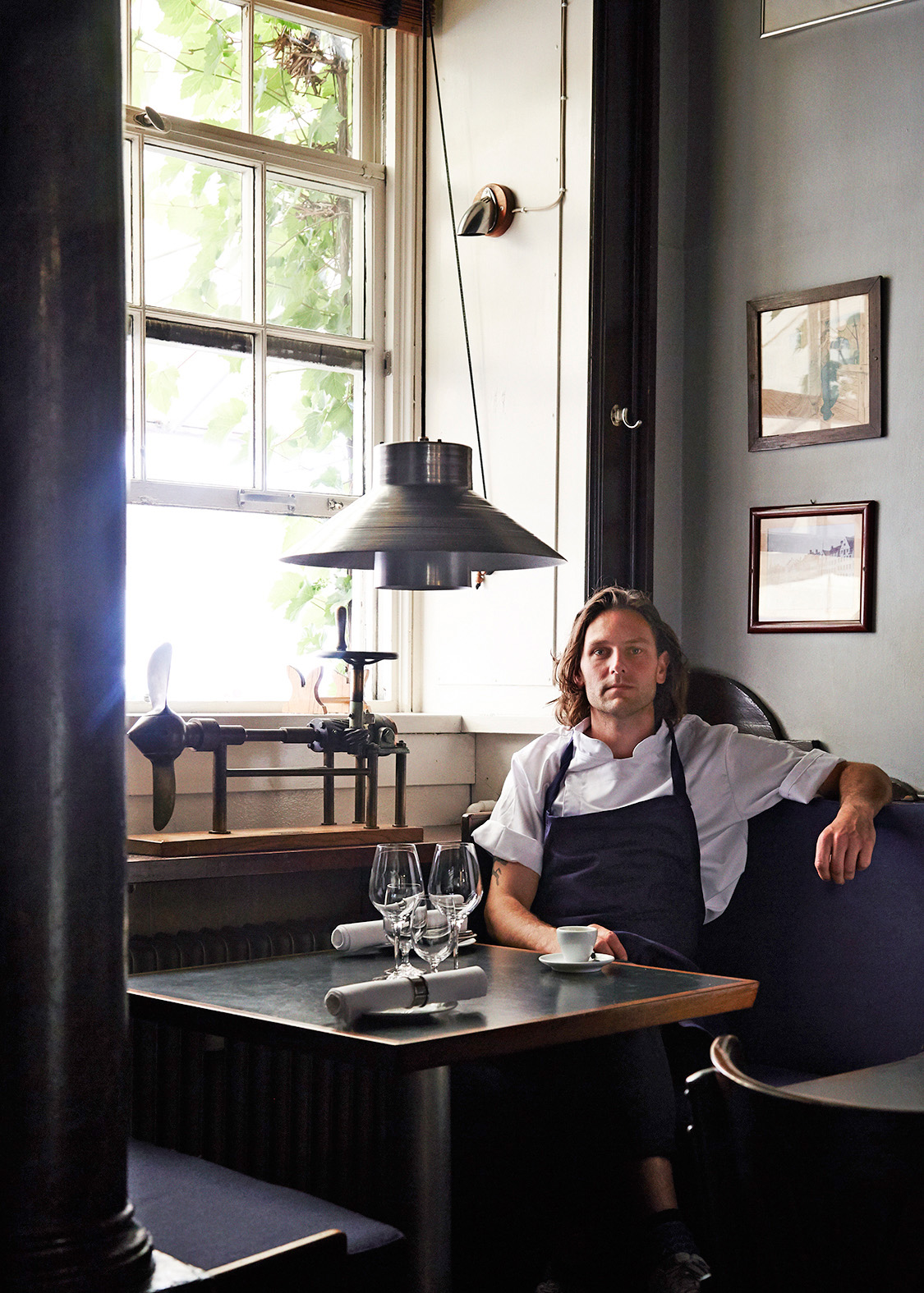 Chef Frederik Bille Brahe seated at a table inside Havfruen restaurant in Copenhagen.