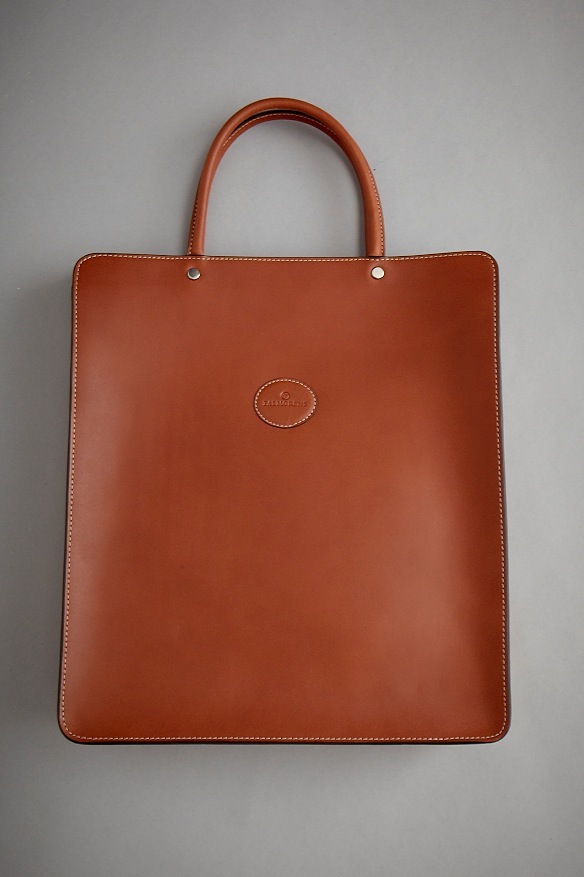 Cognac-colored leather tote bag with double handles and visible stitching by Palmgrens.