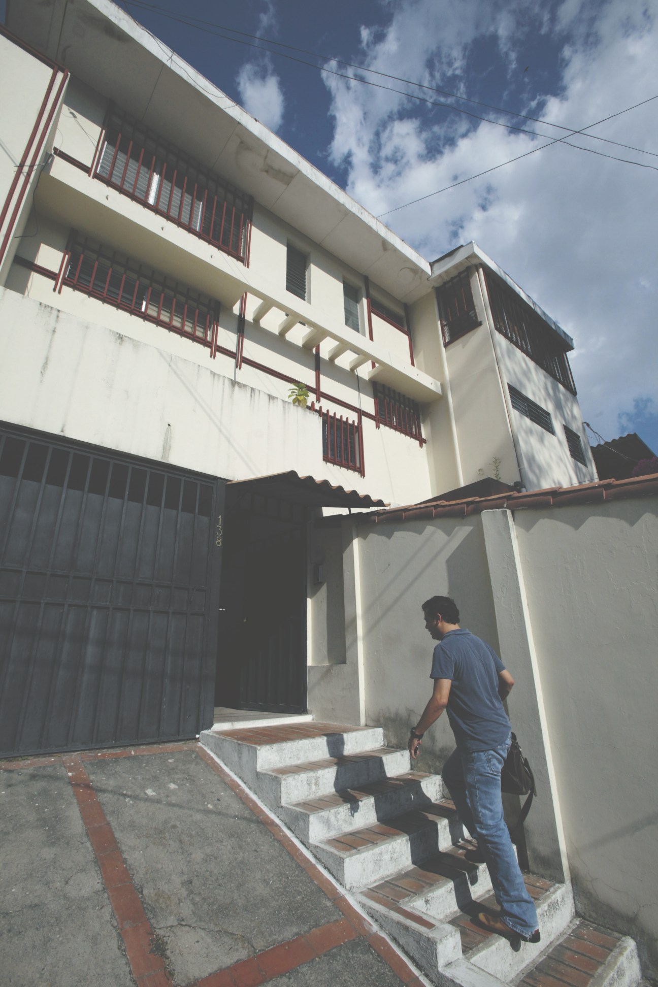Carlos Dada arrives at El Faro offices, climbing exterior steps to a white concrete building in San Salvador.