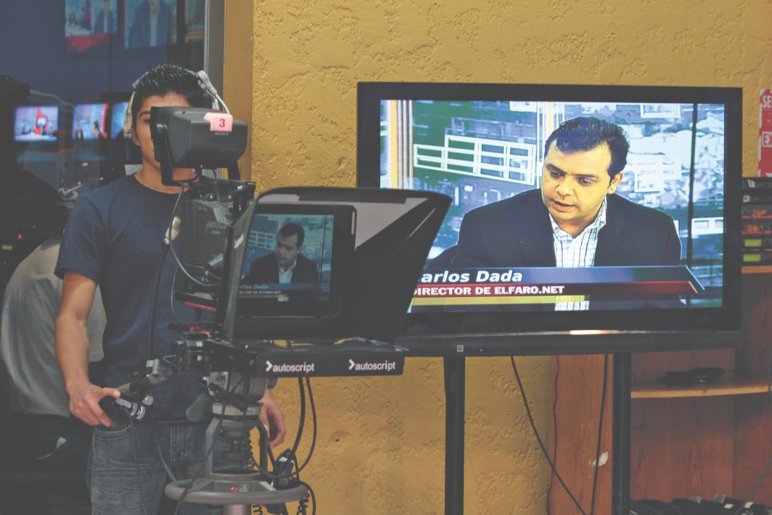 Cameraman filming Carlos Dada on set for Channel 33's television show '8 en Punto' in San Salvador.